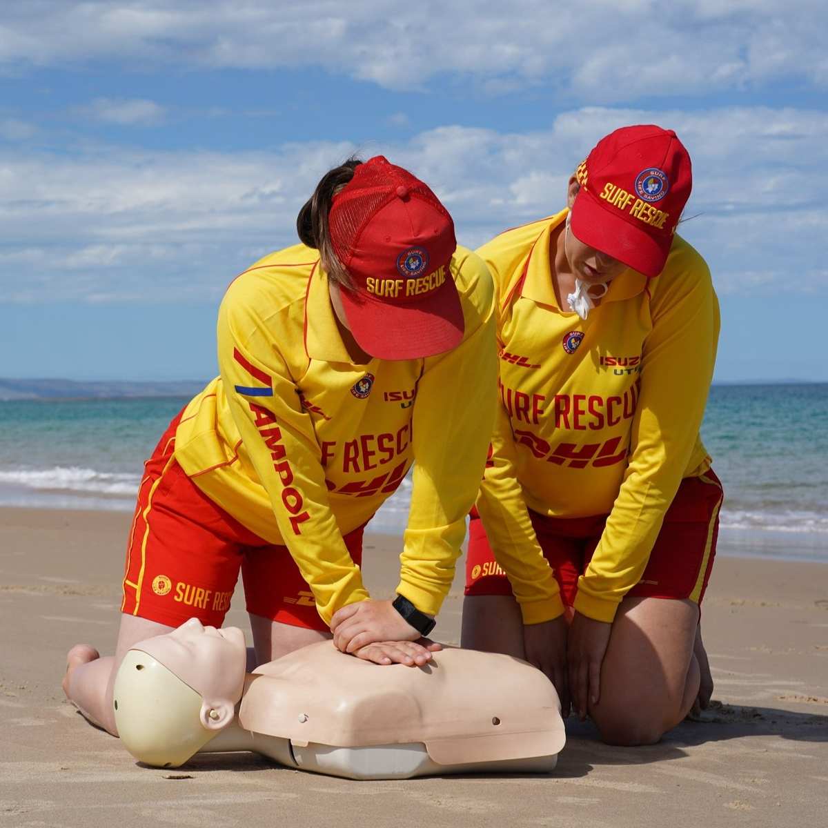 Surf lifesavers practicing CPR training on the beach
